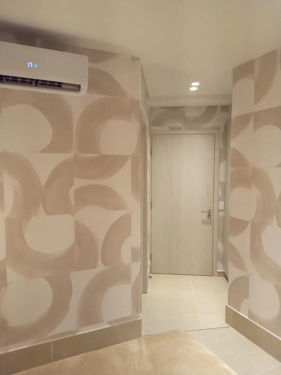 A soft neutral wallpaper with a large curved pattern, running down a hallway
