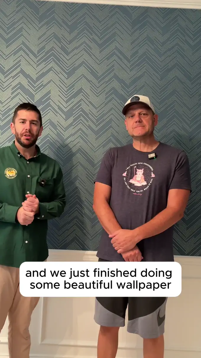 A homeowner in Blue Bell, PA standing with Rick Sabatini in front of the finished blue chevron wallpaper in his hallway